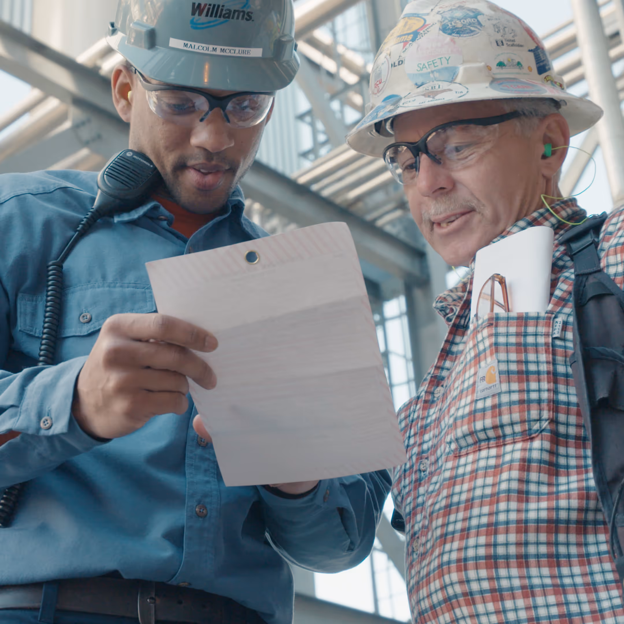 Industrial workers discussing regulations in a chemical plant